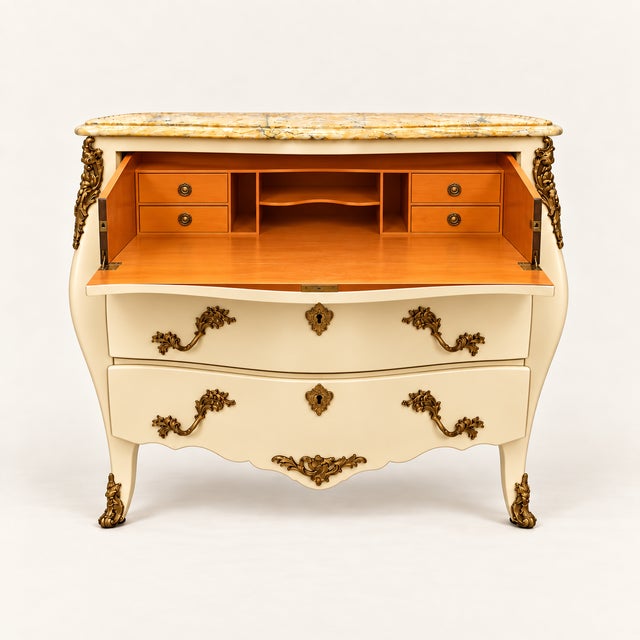 A striking Louis XV-style bombé secretary presented in a soft ivory finish. The curvaceous form is complemented by a...