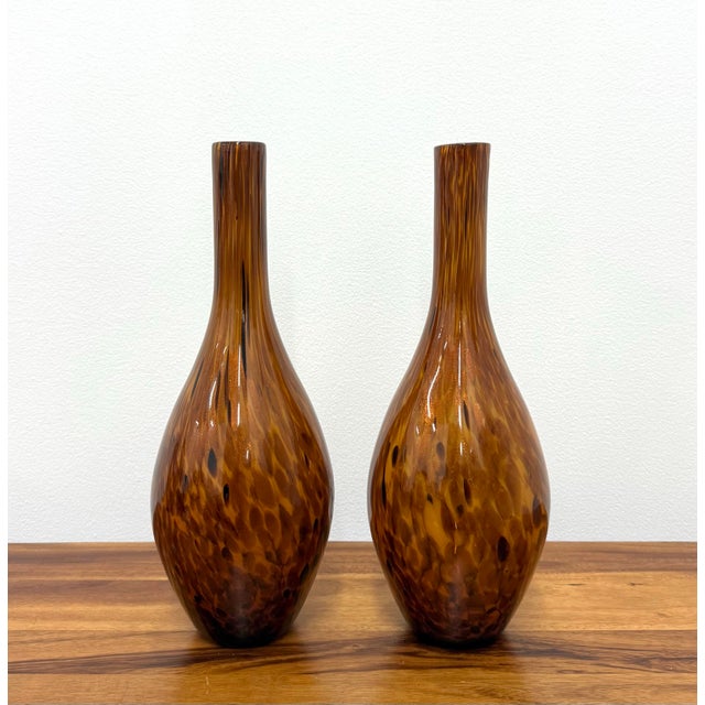 A striking pair of Murano style hand-blown art glass vases featuring elegant bottleneck silhouettes in richly layered...