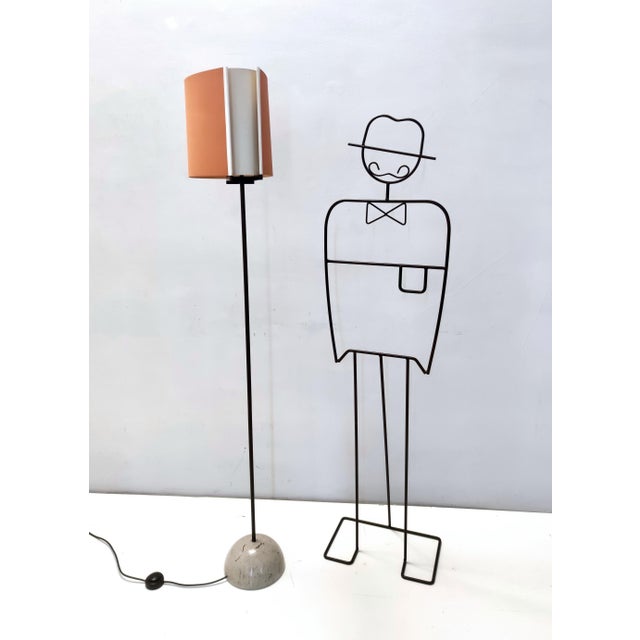 Made in Italy, 1970s - 1980s. This beautiful floor lamp features a black varnished metal and steel frame, a shiny grey...
