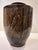 A vintage glazed ceramic vessel with a rounded shoulder and tapered body, finished in a rich brown and dark grey glaze...