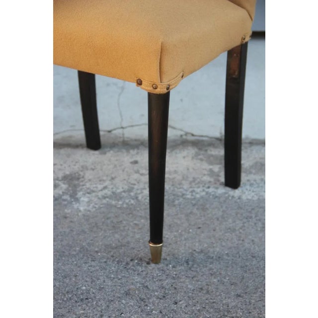 This 1950s chair is upholstered in woolen fabric and has feet in dark mahogany.