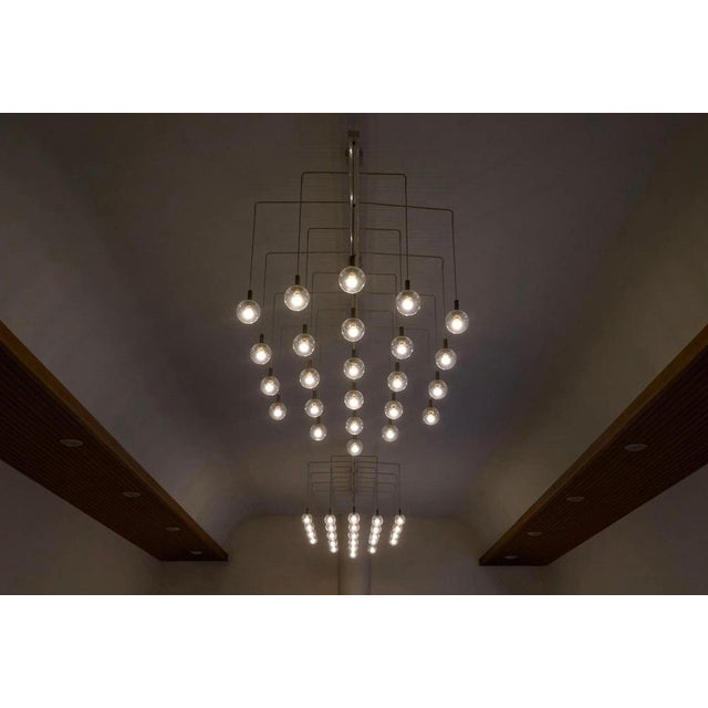 Monumental Pair of Mid Century Chandeliers in Glass, Metal and Patinated Brass, The Netherlands, 1960. A highly unique and...