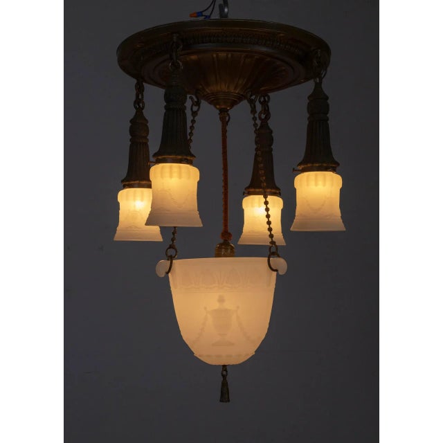 An early 20th century, shower style chandelier with lacquered brass and milk glass. Details include beaded chains, shade...