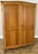 A graceful Vintage French Louis wardrobe crafted from Oak, featuring two panelled doors, a warm natural finish and gently...