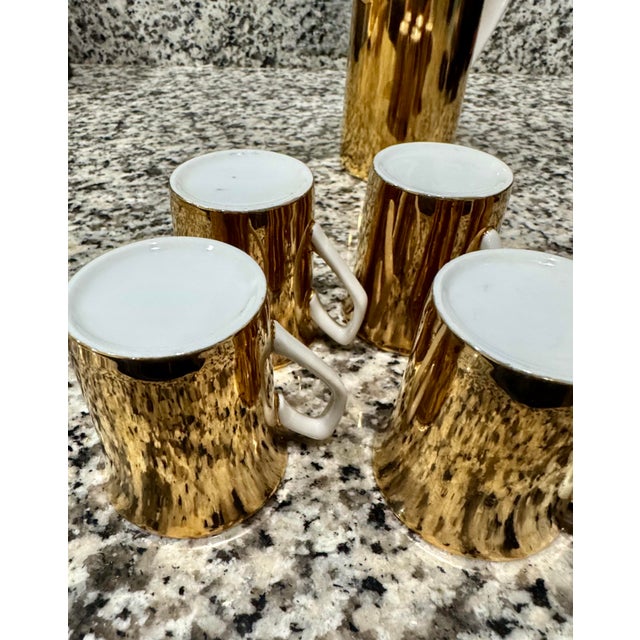 Vintage Gold-Gilded Porcelain Espresso Set (11 - Piece Set) This eye-catching vintage set features a tall, elegant...