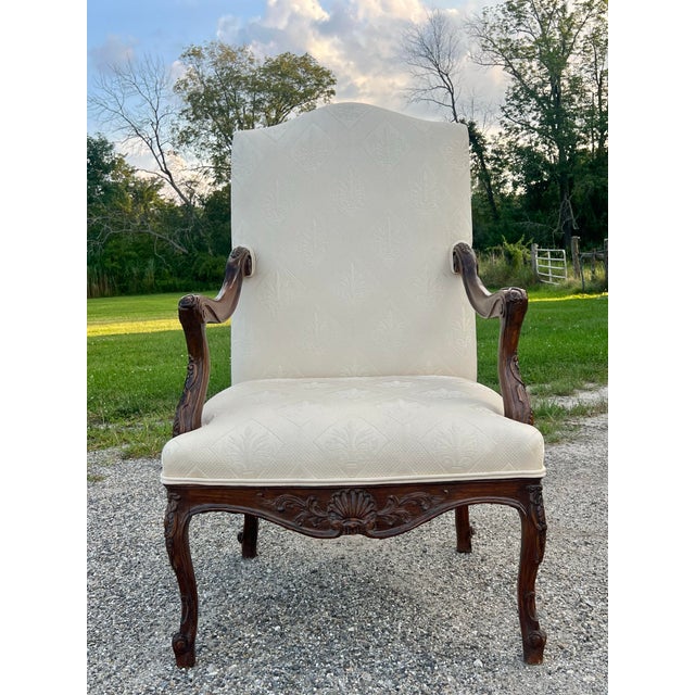 Exquisitely carved solid wood chair upholstered in a tonal cream fabric. Elegant cabriole legs with carvings , carved...