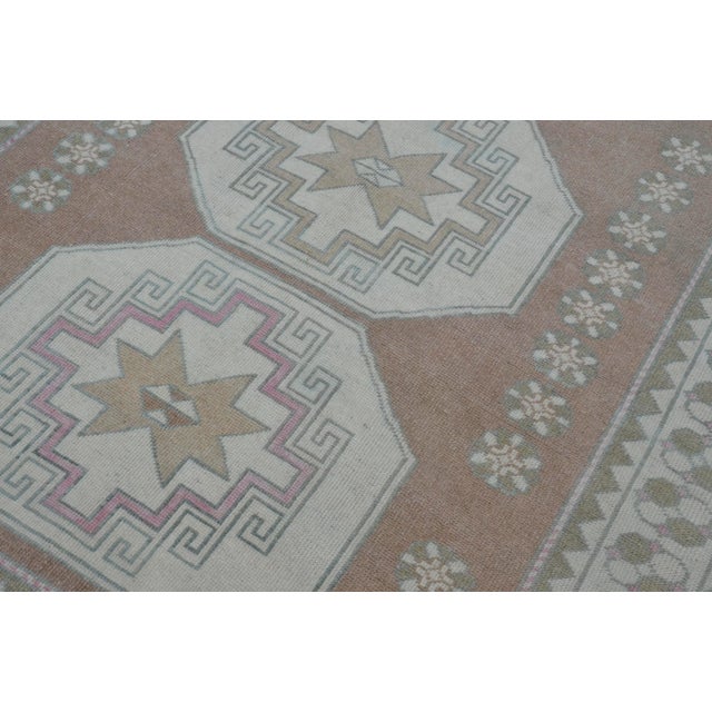 This is a vintage Turkish Oushak rug from the 1960s. The piece was hand-knotted.