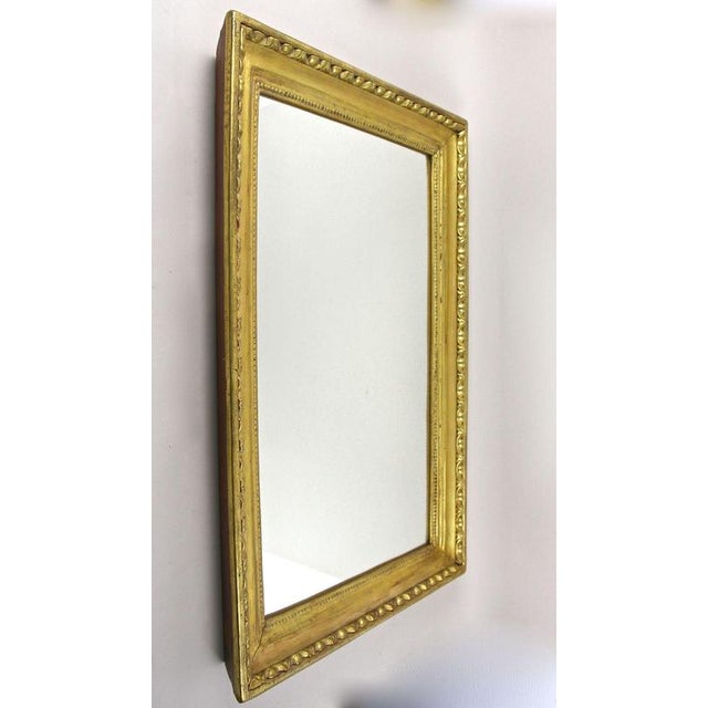 Elegant Austrian Biedermeier wall mirror from the famous period around 1830 in Vienna. The wide, deeply grooved frame -...