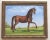 An elegant chestnut horse, this equine figure is set in an open field landscape with a mountainous background with...