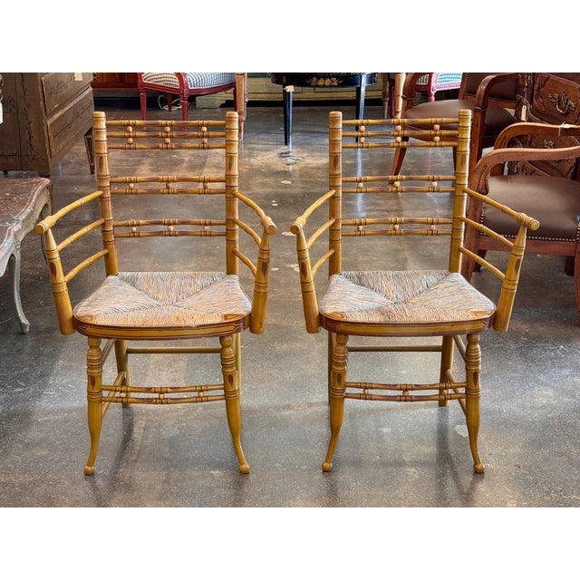 A pair of 19th century painted faux bamboo armchairs, the frames ring-turned in imitation of bamboo on an ochre ground...