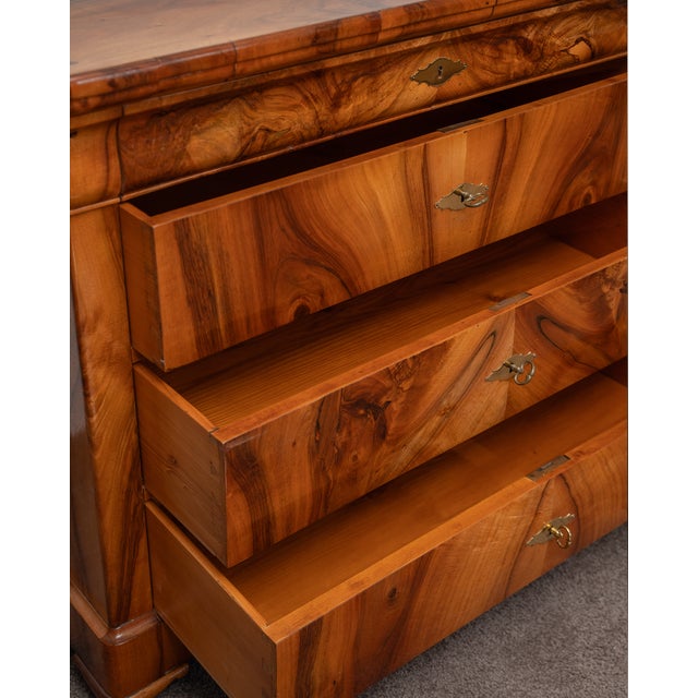 This elegant Biedermeier-style chest of drawers captivates with the harmony of its clean lines and the exceptional beauty...