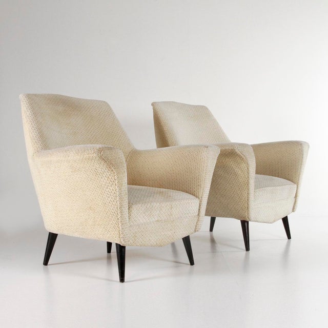 A pair of 1950s Italian armchairs with a simple and refined design, inspired by the language of designers such as Ico...