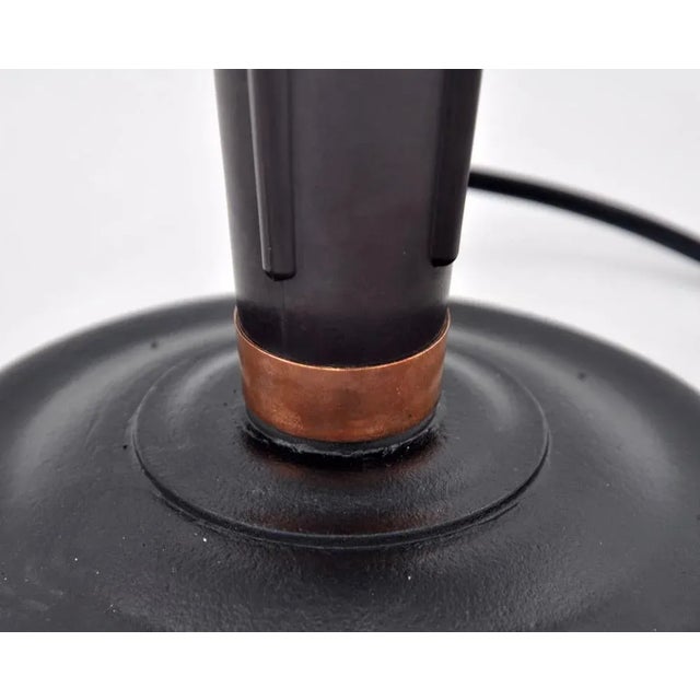 This Art Deco lamp Model 320 from Jumo is made of metal and bakelite and designed by Eileen Gray in the 1940s. The...