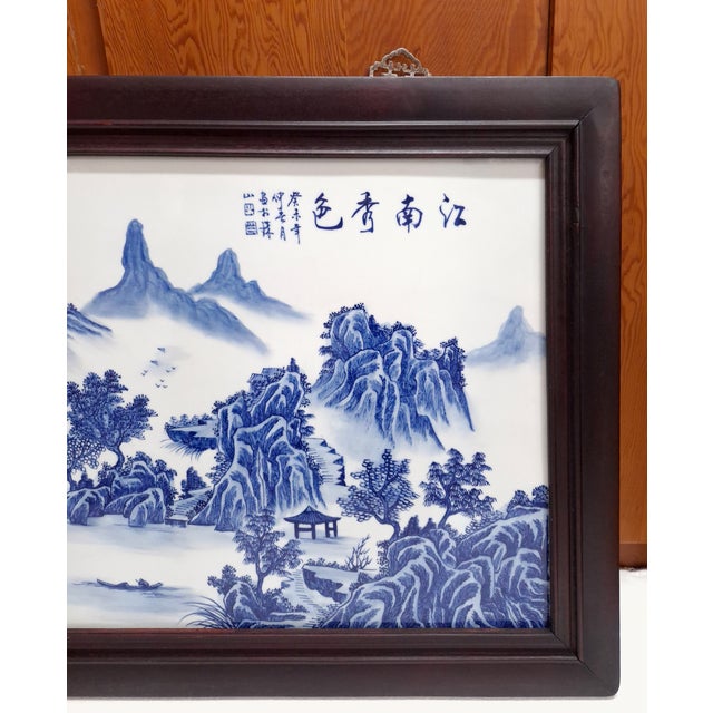 Chinese porcelain Jiangnan scenery plaque, with a finely painted landscape in blue and white glazes of forested, rocky...