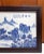 Chinese porcelain Jiangnan scenery plaque, with a finely painted landscape in blue and white glazes of forested, rocky...