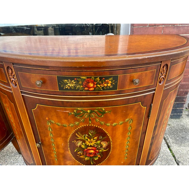 This is a sweet pair of demilune cabinets with beautiful grained veneer painted in the Adams style, each having a gorgeous...