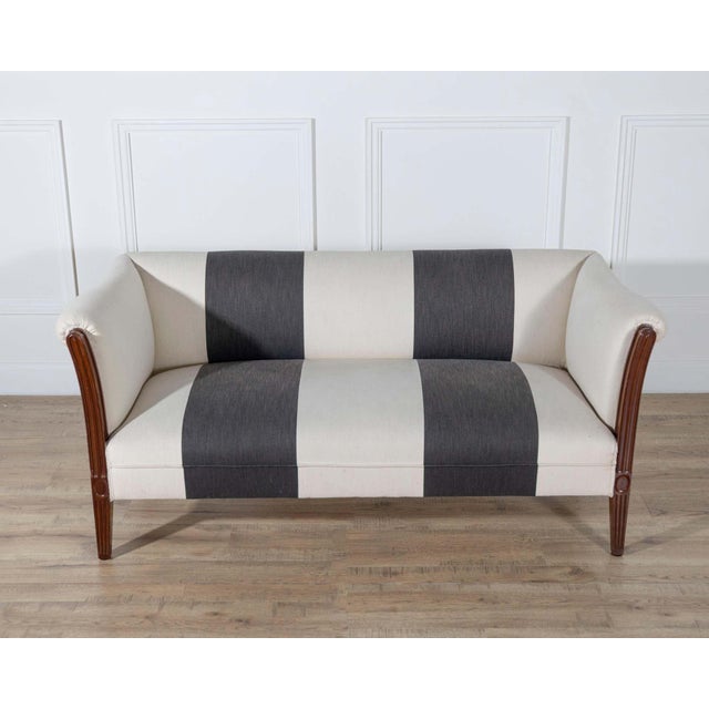 Refined small Italian sofa in solid carved mahogany, dating to the early 19th century. The form is restrained yet...
