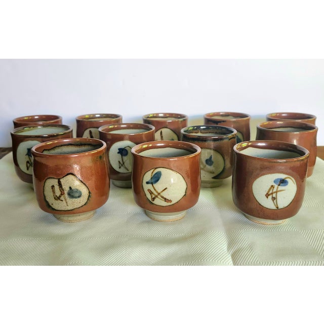 The Mashiko Yaki Japanese Mid-Century Studio Pottery Yunomi Stoneware Teacup is a unique and culturally significant piece...