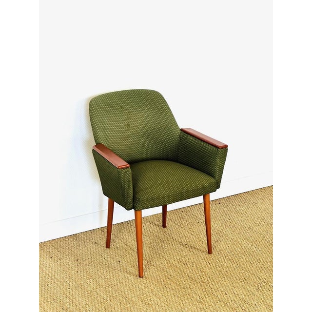 Charming vintage Scandinavian armchair in green fabric, with brown vinyl armrests and tapered wooden legs. Armchair dating...