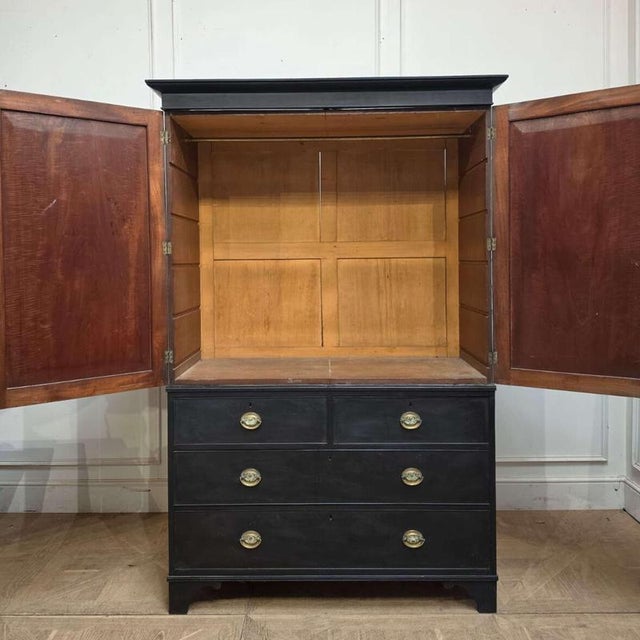 Early 19th C English ebonized linen cupboard with hanging rail. 1830 This piece is designed in the style of the selected...