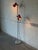 This vibrant floor lamp features two adjustable red shades mounted on a slim chrome standard. The sleek silhouette...