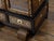 An English miniature cabinet from the 19th century with scrollwork inlay, glass doors and multiple inner drawers. This...