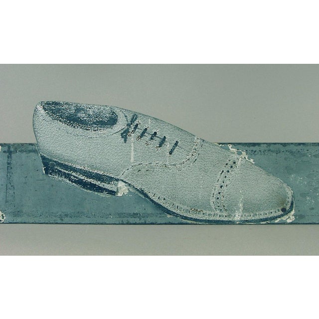 Based on the shoe style (roaring 20s) and the handmade aspect of this totally fabulous advertising sign, I’d say this was...
