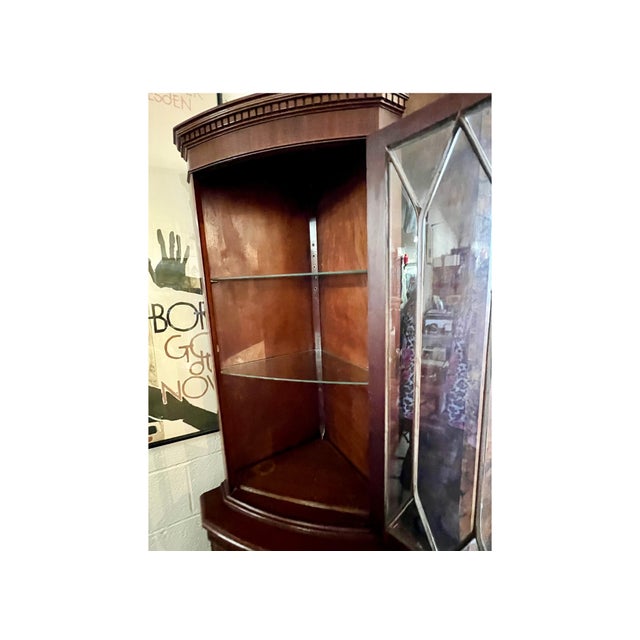 Unique single-door mahogany corner cabinet circa 1940. Features leaded class upper cabinet door and lower cabinet with...