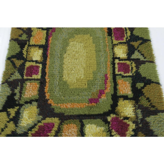 Hand-knotted in lush, high-pile wool in Sweden circa 1960-1970, this 3x5 vintage Swedish Rya rug is a bold new addition to...