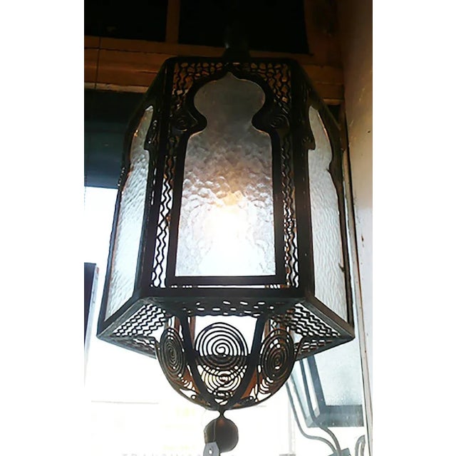 Parisian Art Deco, hexagonal, wrought iron lantern in the Moroccan style having cusped arch panels and textured glass....