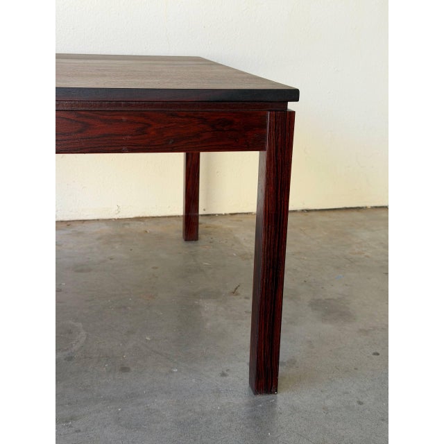 Danish Mid-Century Modern coffee table crafted in richly grained rosewood. This piece features a clean square silhouette...