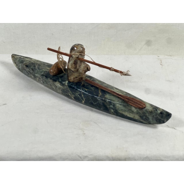 This exceptional vintage hand-carved soapstone sculpture depicts a traditional Alaskan Inuit hunter piloting a kayak....
