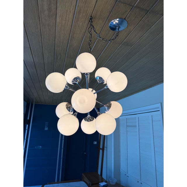 An iconic 1970s Mid-Century Modern Sputnik chandelier by Lightolier, featuring twelve radiating chrome arms fitted with...