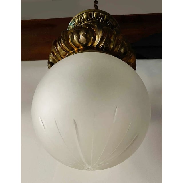 Antique cast bronze flush mount lobby ceiling light with a wheel cut frosted, etched glass globe shade. Provenance:Rare,...