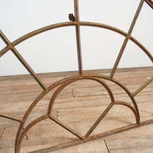 An antique curved cast iron window frame. The metal has rusted over time giving it lots of character and patina, there is...