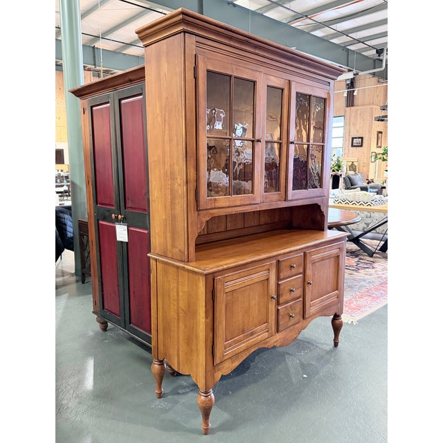 A beautifully crafted two-piece china cabinet from Ethan Allen’s Country Crossings collection, showcasing solid maple...
