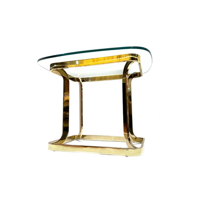 Post Modern abstract brass Milo Baughman style accent table. The table features an elegant and uniquely shaped brass-...
