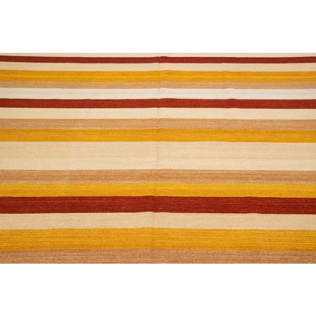 Beautiful Modern Kilim hand-knotted wool rug with multicolor accents in an all-over geometric stripe design. This rug...