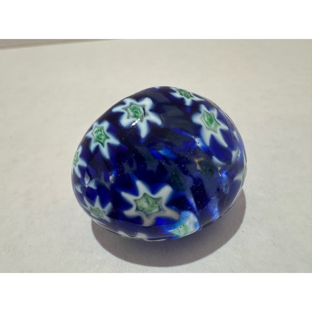 Small vintage egg-form art glass paperweight with cobalt blue ground, white and green millefiori canes, and applied gold...