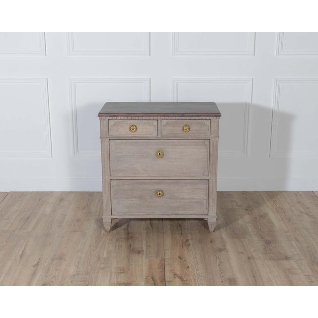 A refined Gustavian-style chest of drawers from Sweden, crafted in pine and painted in warm contrasting tones. The...