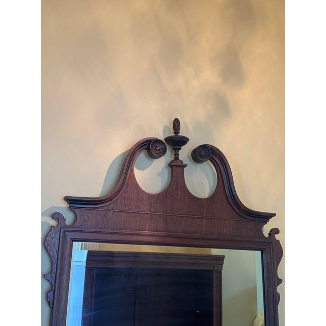 Wall mirror in the Georgian / Chippendale taste: a broken swan-neck pediment centred on a turned urn finial, pierced and...