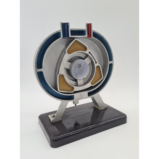 An original, vintage demonstration model illustrating the operating principle of a rotary engine, specifically a Wankel...