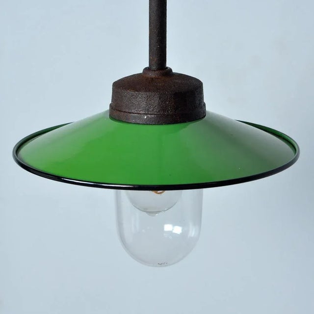The lamp has a thick iron arm with cast iron beginning and end. The enamel green shade is white at the inside for as much...