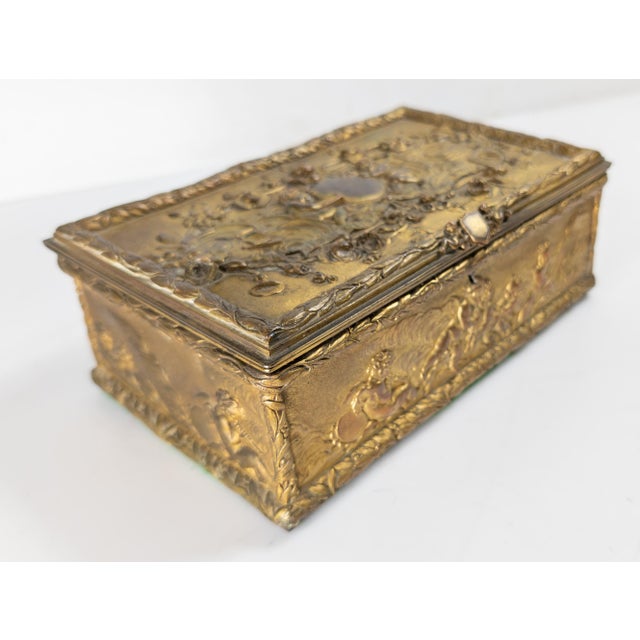 We are selling this pretty French gilt bronze dresser box. This fine box has high quality neo-classical scenes with putti...