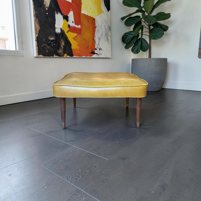 Add a pop of authentic mid-century charm to your living space with this rectangular vinyl ottoman footstool manufactured...