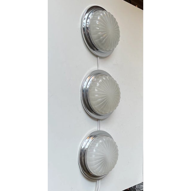 A trio of fixed wall lights in a nautical art deco style. Designed and made by BMAC in Hyde England circa 1960 for an...