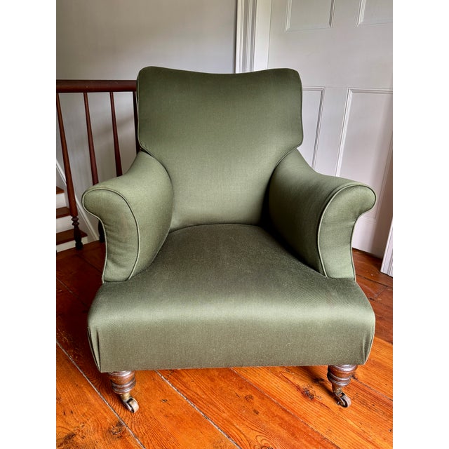 A striking pair of deep wingback lounge chairs in the Napoleon III style, upholstered in a rich olive green fabric. Each...