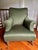 A striking pair of deep wingback lounge chairs in the Napoleon III style, upholstered in a rich olive green fabric. Each...