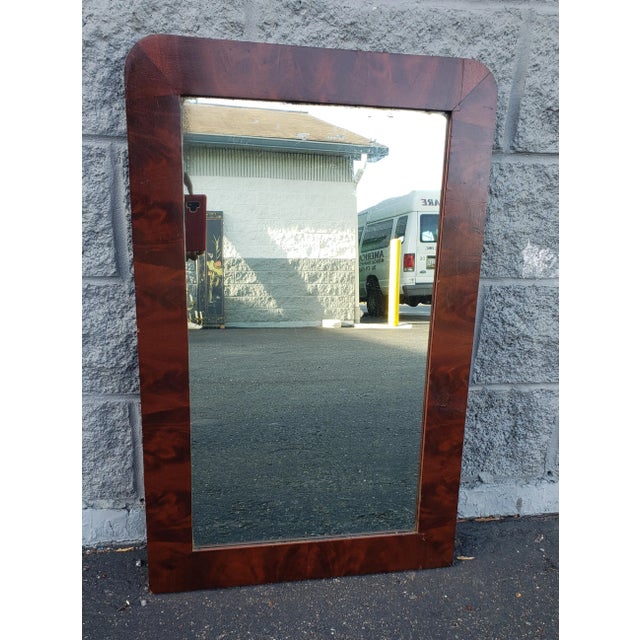 Antique flame mahogany frame wall mirror. Shows age on wood and on mirror,, but in good co dition. Measures 21.25 in width...