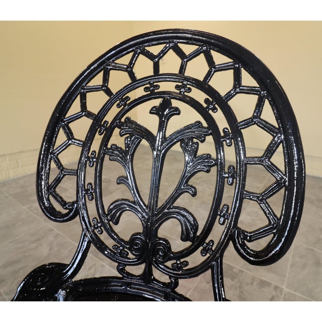 Ornate three-piece garden bistro set comprising two chairs and a round table. The design recalls late-Victorian garden...